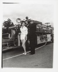 Santa Rosa Fire Chief George H. Magee places a fireman's helmet on Sandra Duden's head, Santa Rosa, California, 1958