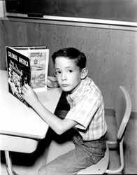 Eddie Anderson reading a book and comic book, Santa Rosa, California, 1966