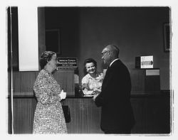 Nellie Urmann issuing travelers checks to a couple at the Exchange Bank, Santa Rosa, California, 1960