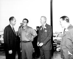 Hugh Codding at microphone of KHUM during grand opening of United California Bank and unidentified men, Santa Rosa , California, 1962