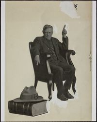 Portrait of a seated man with a Webster's dictionary, photographed during the 1930s