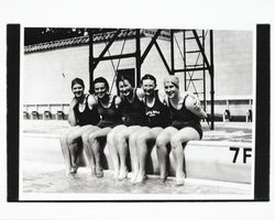 Five girls sitting on the edge of the city municipal pool
