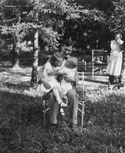 Hans Munk holding his daughter Gertrude and his infant son Walter Munk; the children's nanny is in the background