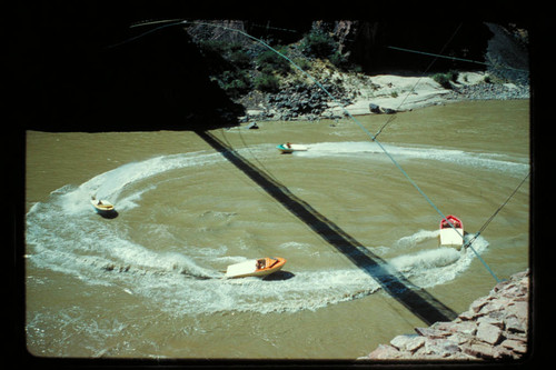 Four boats circle under bridge at Bright Angel Creek
