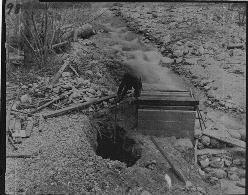 A man tending to the cave--in at the intake at Mill Creek #3 Hydro Plant