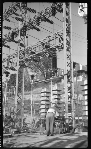 Engineer running tests in switch racks at electric substation