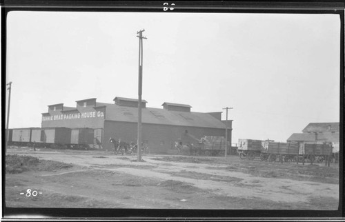 Side view of a packing house in Exeter showing pack horses carrying ...