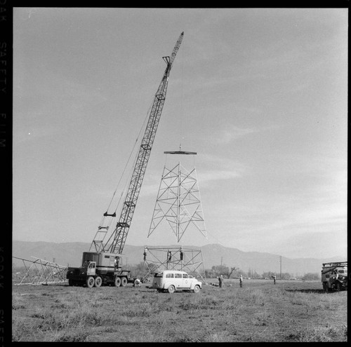 Transmission tower construction using a crane