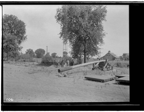 View of men at Visalia Steam Plant erecting an experimental steel pole