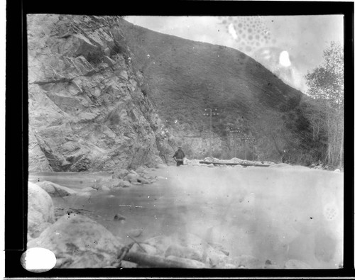 A man walking along the Santa Ana River transmission line in the canyon