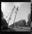 Distribution poles with cross-arms being removed (or replaced) with a crane