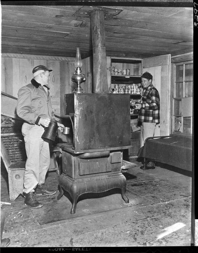 Two men in Kaiser Meadow shelter cabin used during snow surveys