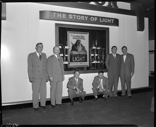 Edison display booth exhibiting the "Story of Light" with six men posed in the shot