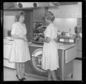 Women demonstrating Medallion Home electric cooking equipment at a promotional event