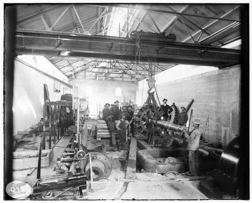 A construction crew gathered around the field that is ready for bearings in the interior of Mill Creek #3 Hydro Plant during construction