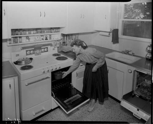 Woman placing food in oven