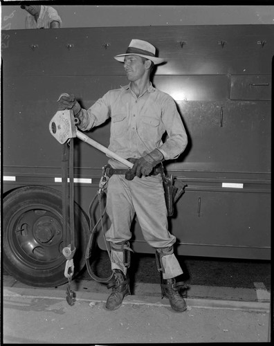 Lineman with Hi Line Hoist standing by line truck