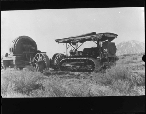 Caterpillar pulling wagon with Hydroelectric generator through desert