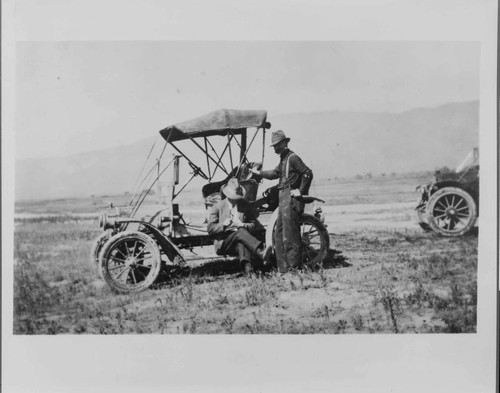 H.N. Siegfried and driver during a survey for new business, about 1915