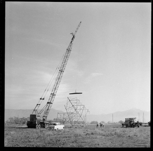 Transmission tower construction using a crane