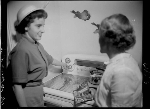 Two women talking by electric range