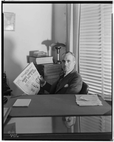 Manager/editor of Huntington Park Signal at his desk with front page of newspaper