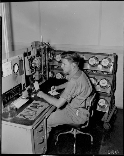 Young man at desk testing electric meters