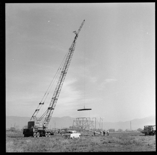 Transmission tower construction using a crane