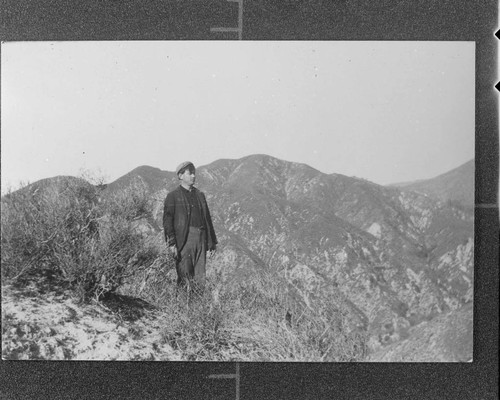 Operator Taylor standing on the summit of the peak opposite the power house at Santa Ana River #1 Hydro Plant