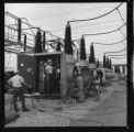 Men working on, or installing large oil circuit-breakers at a transmission substation