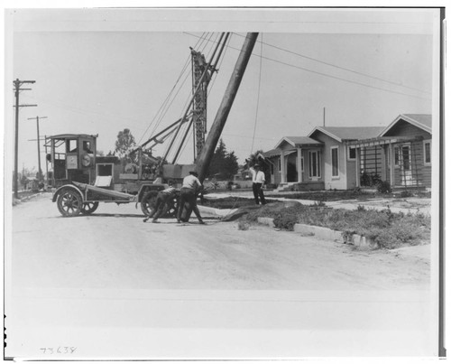 A city crew sets a pole in South Central Los Angeles