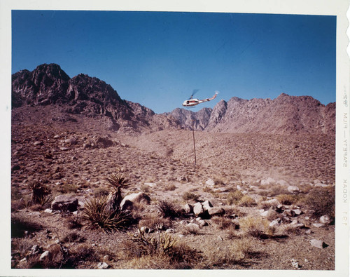 Helicopter planting pole in desert