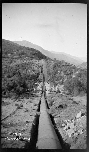 Long view of the siphon pipe line of Kaweah #3 Hydro Plant showing the mountains in the background