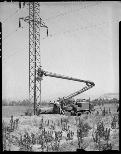 Raising boom at double circuit tower in desert