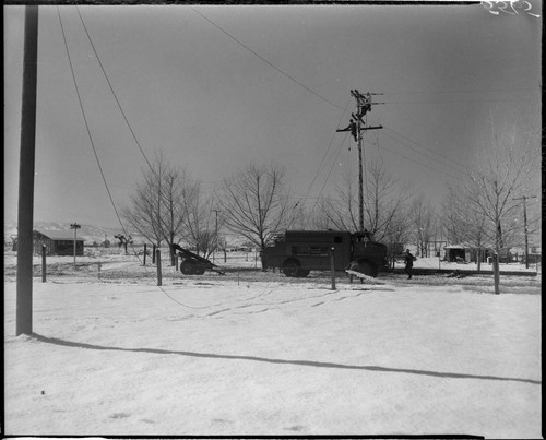 Linemen working on pole in snow at corner of Ave. K