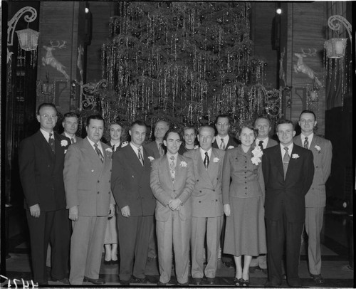 Group of people standing in front of Christmas Tree