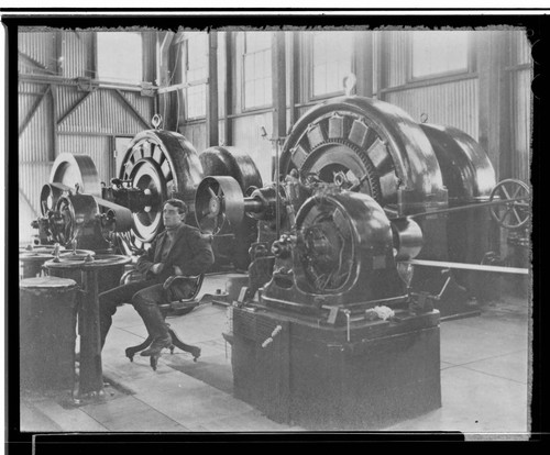 An interior view of Kaweah #1 Power House showing the operator sitting in front of the generators