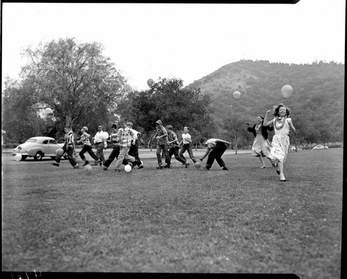 Kids in the park in a balloon race