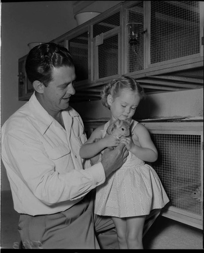 Man with his little daughter holding a chinchilla