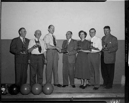 Five men and a woman receiving bowling trophys