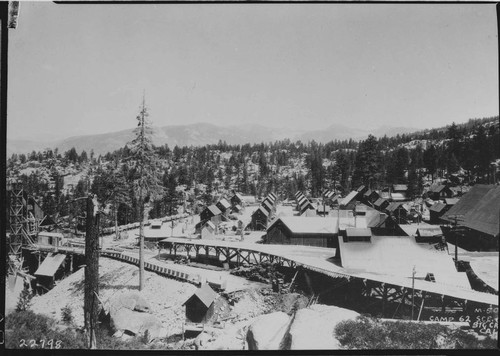 Establising shot of Camp 62 showing snowshed over tunnel tracks in foreground and concrete aggregate crushing and screening plant at extreme left