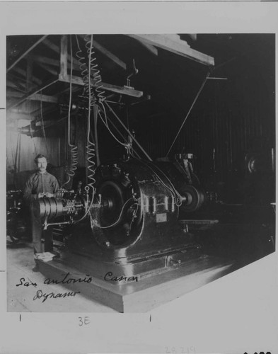 A.W. Decker standing beside a generator at the Pomona Plant