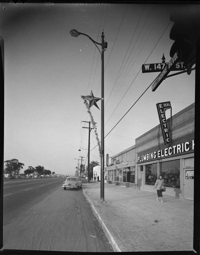 Christmas decoration on streetlight in front of Plumbing & Electric storefront at Hawthorne & 147th Street