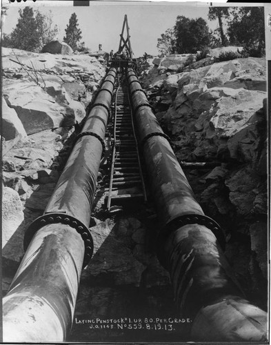 This dramatic view shows the penstock being laid up the 80 percent grade above Powerhouse #1 during August of 1913