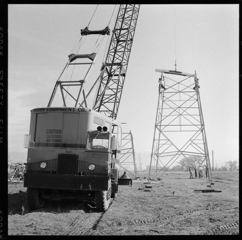 Transmission tower construction using a crane