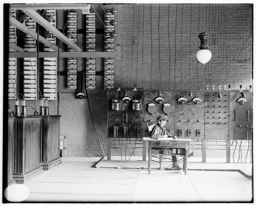 An operator sitting at the desk in front of the switchboard at the Pomona Substation