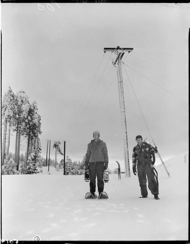 Two men with snow shoes in front of Sno