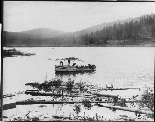 A boatload of officials tours the growing reservoir that will soon be named "Huntington Lake."