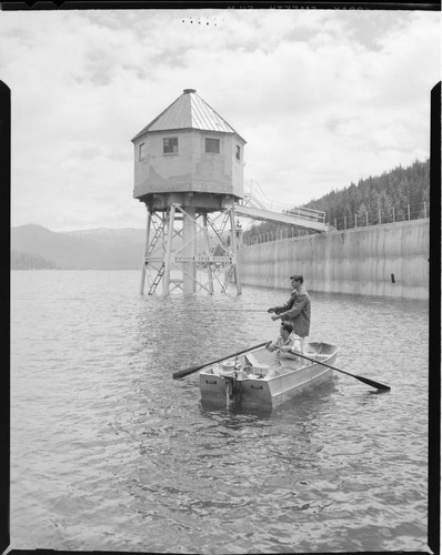 Man fishing from boat on Huntington Lake next to Powerhouse 1 intake at Dam 1