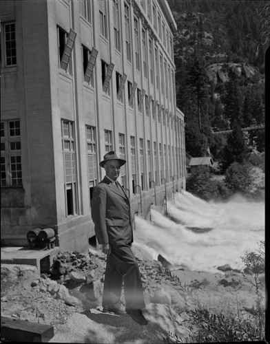 Dave Redinger (in suit and hat) standing near the tailrace at Powerhouse #1